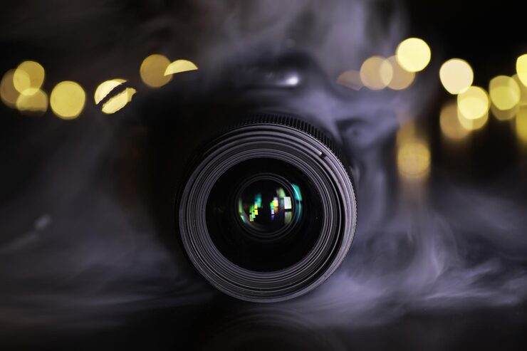 Professional camera lens with bokeh lights representing photography services